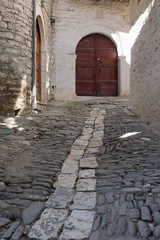 medieval street with wooden door in Berat city, Albania, vertical