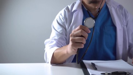 Smart medical doctor working with stethoscope and futuristic computer on desk in modern office with VR graphic icon interface in 4K (UHD) - Powered by Adobe