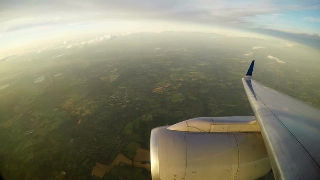 View from aircraft window of engine and England below