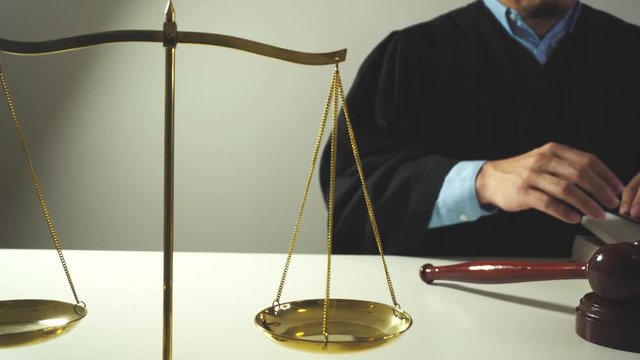justice and law concept.Male judge in a courtroom with the gavel,working with bible book and eyeglasses on white table in 4K(UHD)