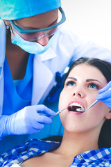 Woman dentist working at her patients teeth