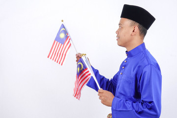 Asian young man with Malaysia flag for National Day celebration.