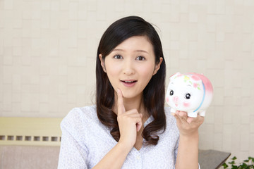 貯金箱を持つ女性