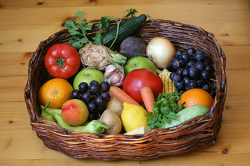 Fruits and vegetables basket on wooden background; selective focus.