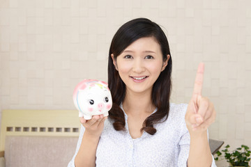 貯金箱を持つ笑顔の女性