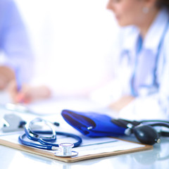 Portrait of young female doctor sitting at desk in hospital