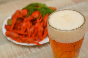 A glass of beer with boiled crayfish with dill. Seafood. Snack to beer.