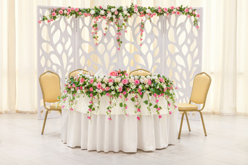 The main table of the newlyweds, decorated with a floral composition and an arch in pastel colors