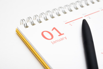 Desk calendar and pen on white background