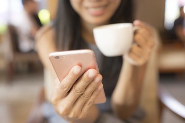 Women are drinking coffee She uses the phone to communicate. Concept, working women, technology, business cafe