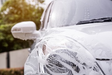 Vehicle condition being washed, white car, car wash concept