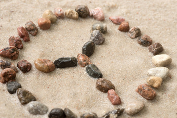 pebble peace symbol on sand  selective focus