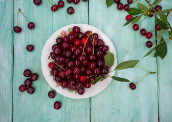 sour cherries on turquoise wooden surface