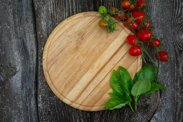 round cutting board and tomatoes on wooden surface