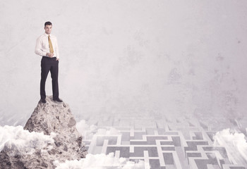 Businessman on cliff above labyrinth