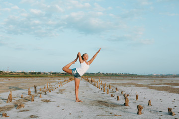 Pretty woman doing yoga on the ground outdoors