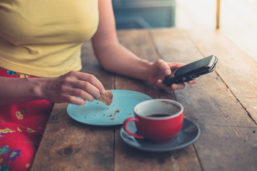Fototapeta na wymiar Young woman using smartphone in cafe