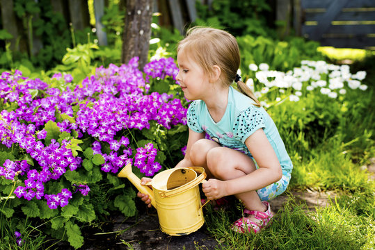 The girl with a watering can in a garden