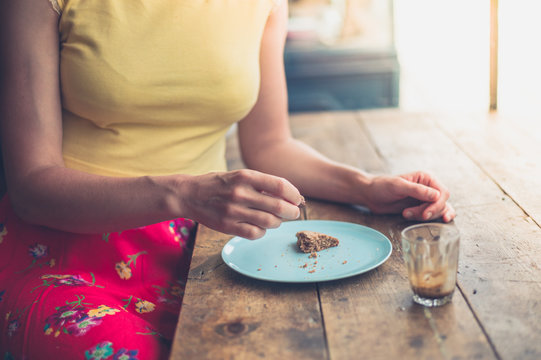 Young woman eating cookie in cafe