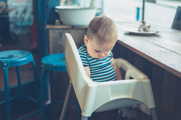 Baby in high chair by the window