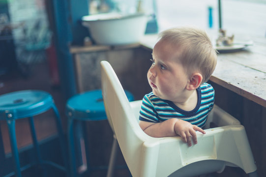 Baby in high chair by the window
