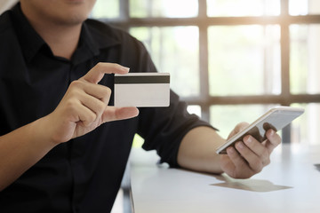 Hands holding credit card and entering security code using smart phone online shopping concept.