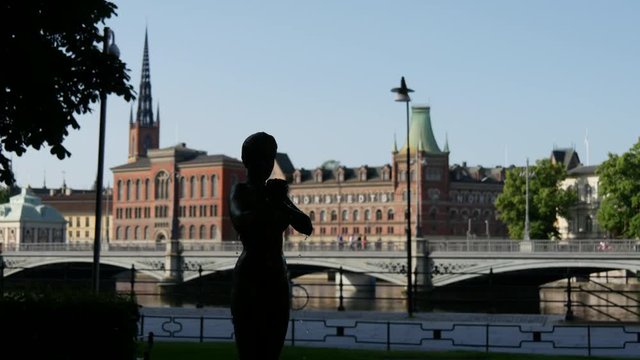 Woman statue fountain with the Riddarholm Church and the Vasabron bridge