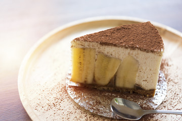 Banoffee pie with chocolate powder on wooden plate