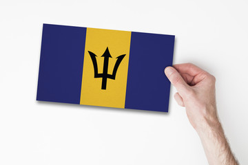 Male hand holding barbados flag