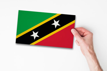 Male hand holding saint kitts flag