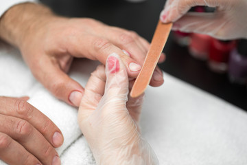 Obraz na płótnie Canvas Girl manicurist doing manicure for man in beauty salon