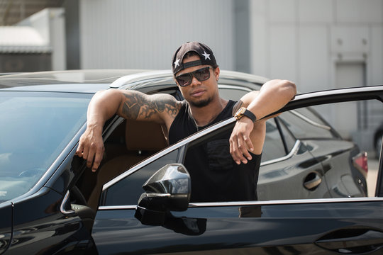 Stylish black man, standing beside his fancy car