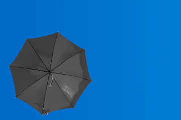  parasol noir sur fond de ciel bleu 