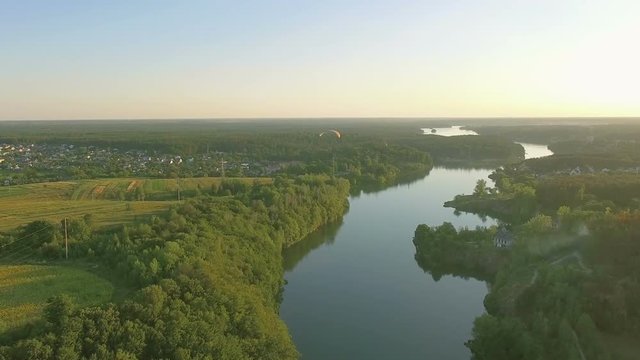 Aerial Paraplane hang glider in the air above river city canyon