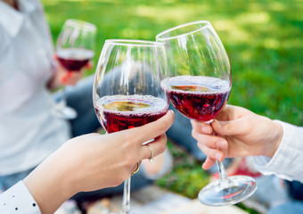 Young beautiful girls with glass of red wine in the park