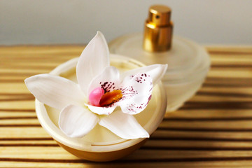 Obraz na płótnie Canvas bottle of essential oil and orchid flowers