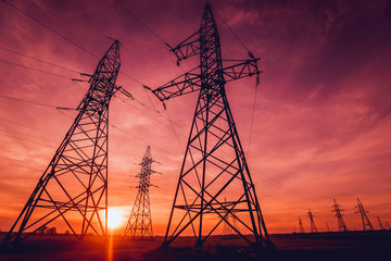 High-voltage power lines at sunset. Electricity distribution station.