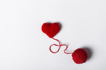 Close up of a wool ball and heart shape on white background. Heart shaped woolen yarn. Love Crochet.