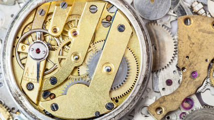 brass mechanical watch on heap of spare parts