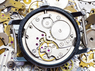 open mechanical wristwatch on pile of spare parts