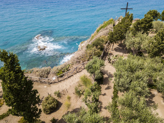Vista aerea di una croce sul promontorio del Santuario di Santa Maria dell’isola, Tropea, Calabria, Italia. Giardini del santuario. Mare ed onde