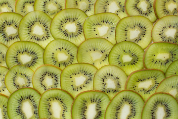 Bright green background with slices of juicy kiwi. Healthy food background.