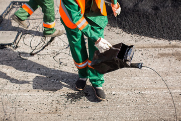 The man working asphalt pouring tar for road repair