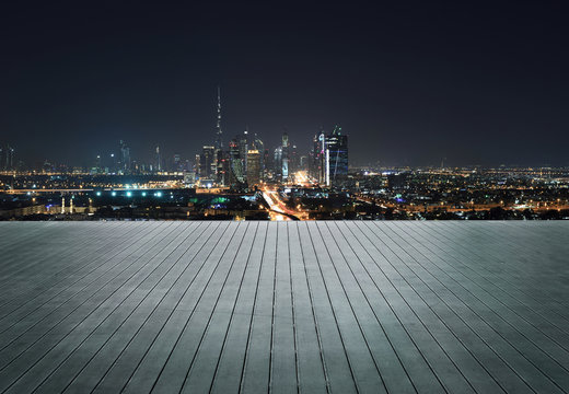 Wooden terrace with skyline of Dubai at night