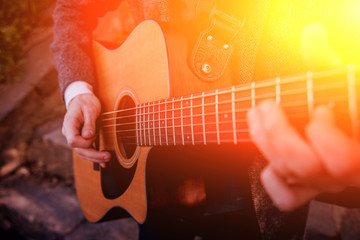 Man's hands playing acoustic guitar. Background