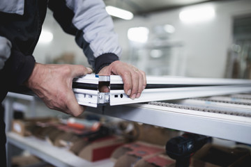 Manual worker assembling PVC doors and windows. Manufacturing jobs. Selective focus. Factory for aluminum and PVC windows and doors production.