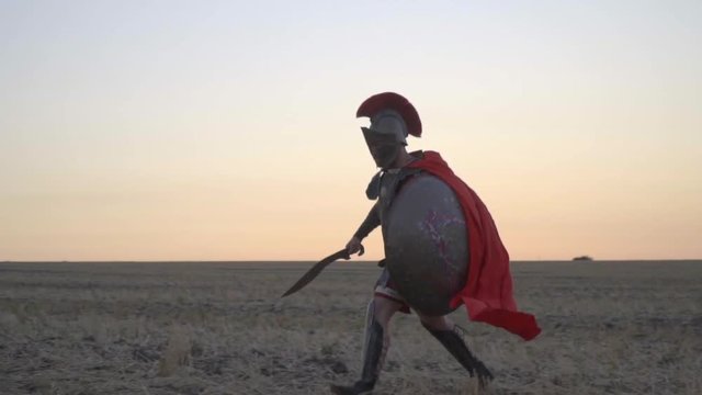 A brave Roman legionary walks the field before dawn, bit slow motion
