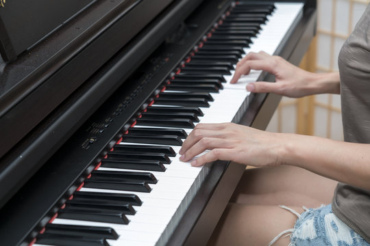 Young pretty female playing piano