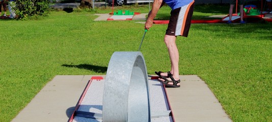 Älterer Mann bei einer Partie Minigolf