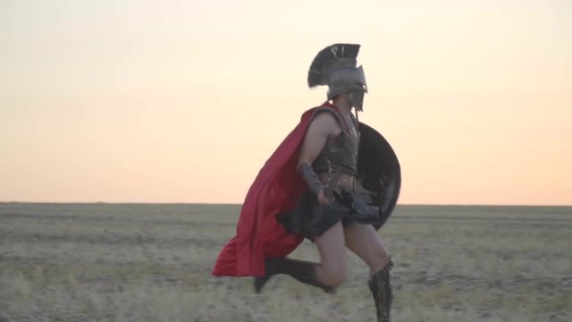 Two Roman legionaries run towards each other and issue a battle cry and begin fight on swords, slow motion